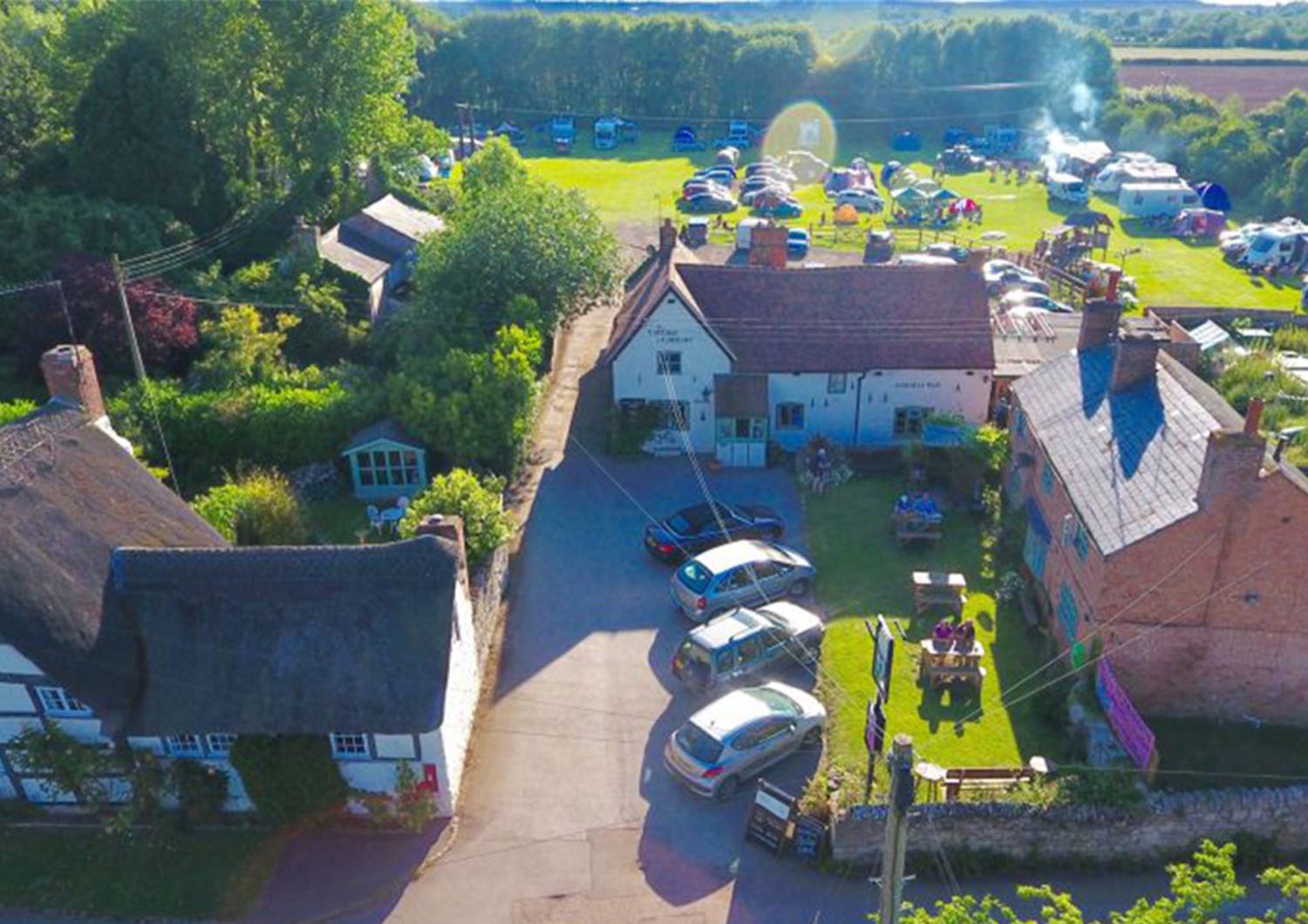 Aerial view of The Cottage of Content with the campsite field laid out behind it.